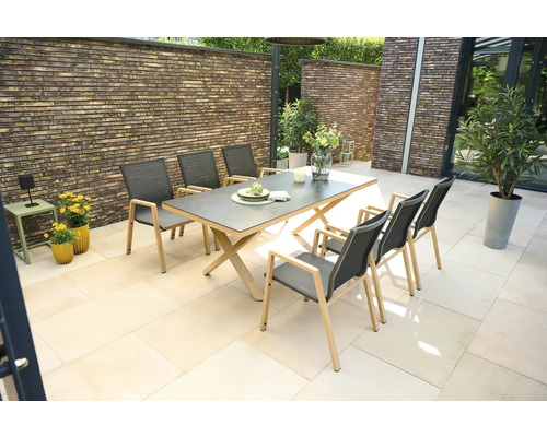 Gartenszene mit Esstisch und sechs Stühlen auf einer Terrasse.