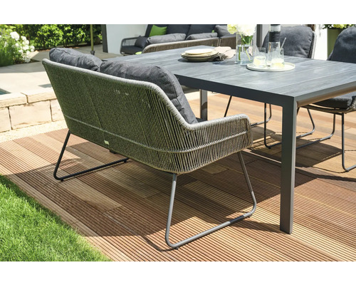 Banc de jardin avec coussins et table sur une terrasse
