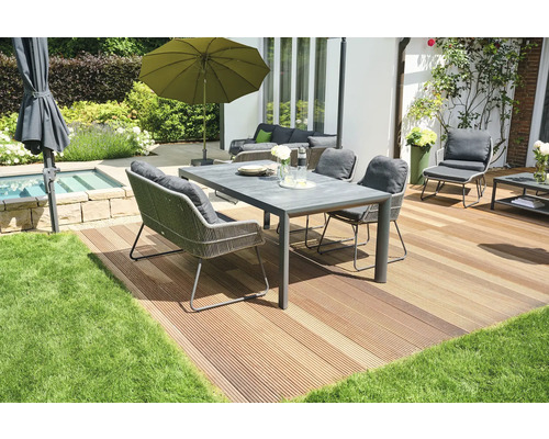 Ensemble de meubles de jardin sur une terrasse en bois avec parasol et plantes