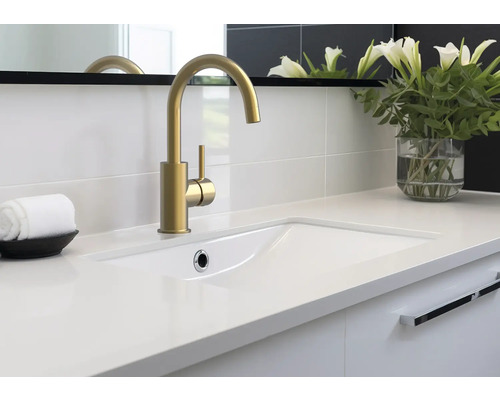 Badezimmerwaschtisch mit goldener Armatur, weißem Waschbecken und dekorativer Blumenvase