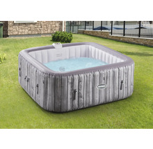 Jacuzzi gonflable aspect bois dans le jardin.
