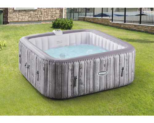 Jacuzzi gonflable aspect bois dans le jardin.