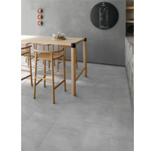 Heller Raum mit Esstisch und Stühlen auf grauem Fliesenboden.