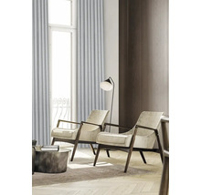 Salon avec deux fauteuils, lampadaire et rideaux devant une fenêtre