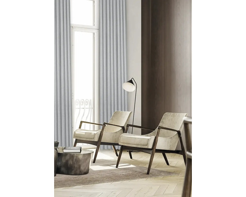 Salon avec deux fauteuils, lampadaire et rideaux devant une fenêtre