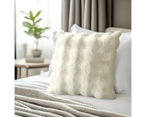 Coussin décoratif en fourrure sur un lit dans une chambre.