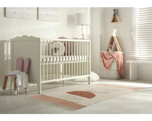 Chambre d''enfant avec lit à barreaux, chaise à oreilles de lapin et tapis à formes géométriques.