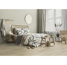 Chambre lumineuse avec lit, éléments en rotin et accessoires décoratifs pour une atmosphère relaxante