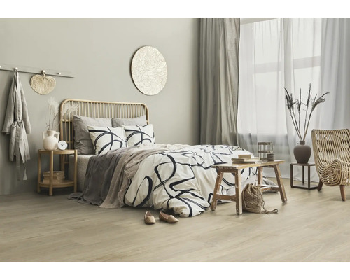 Chambre lumineuse avec lit, éléments en rotin et accessoires décoratifs pour une atmosphère relaxante