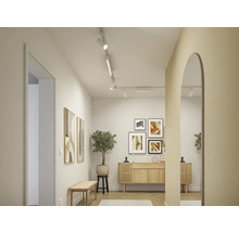 Couloir lumineux avec commode en bois, tableaux et miroir