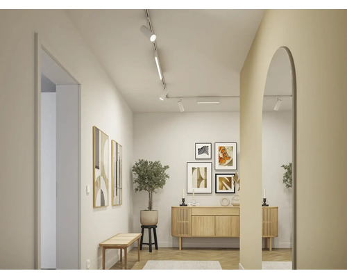 Couloir lumineux avec commode en bois, tableaux et miroir
