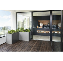 Balcon avec jardinières et cuisine ouverte avec une femme qui cuisine