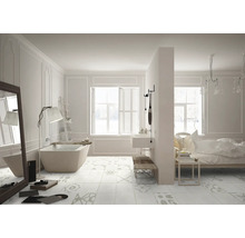 Salle de bains lumineuse avec baignoire îlot, lavabo, miroir, étagère échelle et carreaux de sol à motifs.