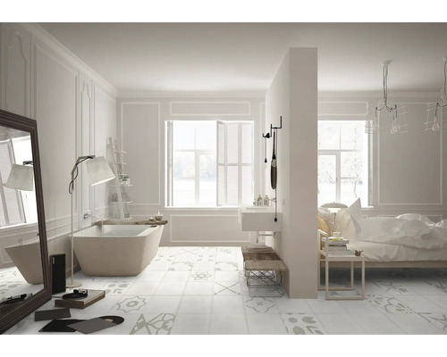 Salle de bains lumineuse avec baignoire îlot, lavabo, miroir, étagère échelle et carreaux de sol à motifs.