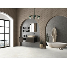Salle de bains lumineuse avec meuble-lavabo, miroir, baignoire et mur en briques