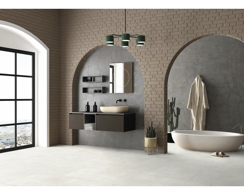 Salle de bains lumineuse avec meuble-lavabo, miroir, baignoire et mur en briques