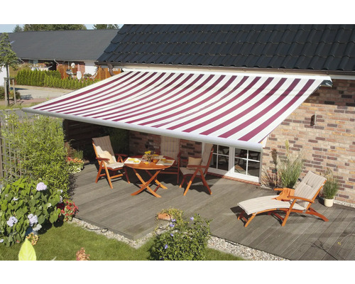 Terrasse mit Markise, Tisch und Gartenmöbeln.