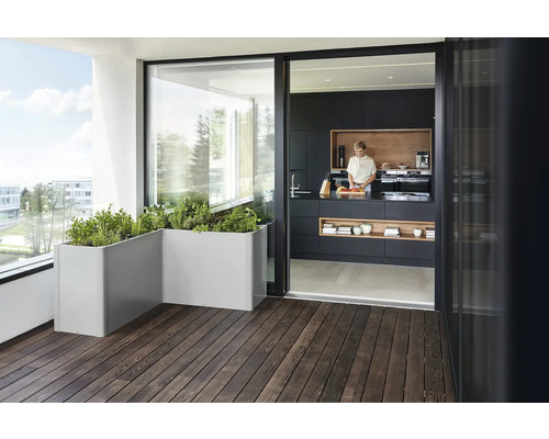 Terrasse au design moderne avec plancher en bois, jardinières et passage ouvert vers la cuisine