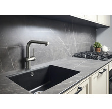 Scène de cuisine avec évier, robinet et plaque de cuisson sur un plan de travail aspect marbre.