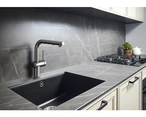 Scène de cuisine avec évier, robinet et plaque de cuisson sur un plan de travail aspect marbre.