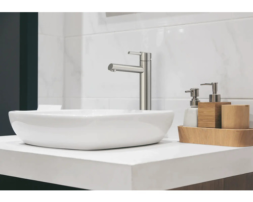 Modernes Badezimmerwaschbecken mit Armatur und Seifenspender auf einer weißen Arbeitsplatte