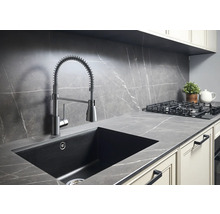 Scène de cuisine avec évier, robinet à ressort spiralé, cuisinière à gaz et plan de travail aspect marbre