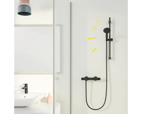 Badezimmer mit Waschbecken, Armatur und schwarzer Duschgarnitur vor weißem Hintergrund