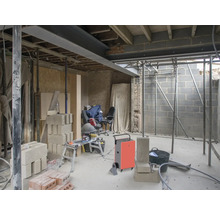 Intérieur en construction brute avec matériaux de construction et équipements de construction