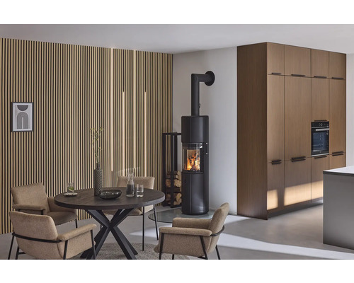 Wohnraum mit Esstisch, Stühlen, Holzofen und Holzverkleidung