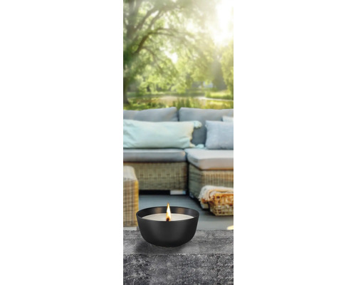 Bougie décorative dans un récipient noir sur une terrasse