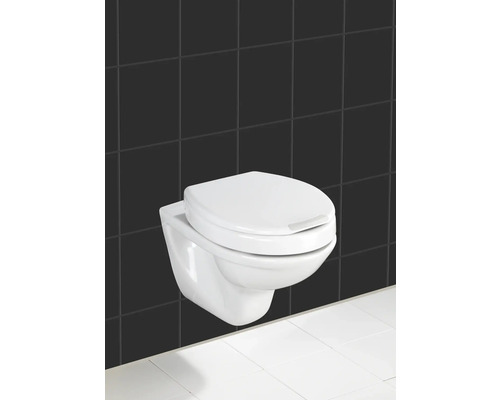 WC suspendu à fond creux devant un fond de carreaux noirs