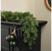 Dekorierter Kaminsims mit Tannengirlande und Weihnachtskugeln für festliche Atmosphäre