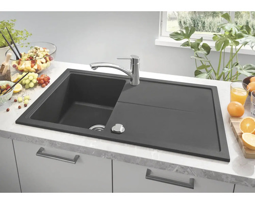 Évier de cuisine gris foncé avec égouttoir et robinet sur un plan de travail