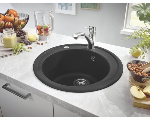 Évier de cuisine rond noir avec robinet sur un plan de travail