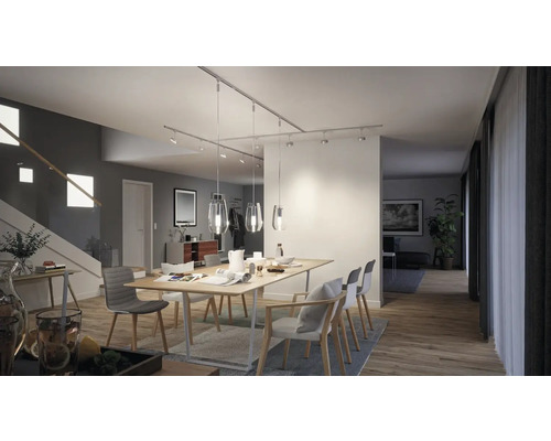 Salle à manger avec table, chaises et luminaires de plafond sur un système de rails