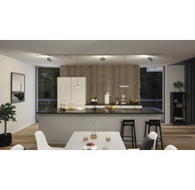 Cuisine moderne avec îlot de cuisson, table à manger et système de rails avec spots