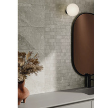 Aménagement mural avec des carreaux aspect pierre et des carreaux de mosaïque, combinés avec un miroir et une lampe