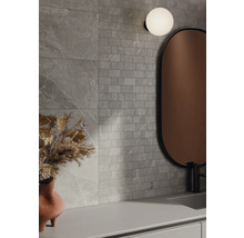 Salle de bains avec carreaux muraux gris aspect pierre, miroir et lampe