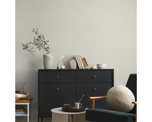 Salon avec commode, fauteuil et éléments décoratifs pour un intérieur élégant