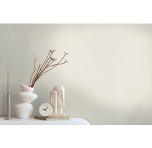 Scène décorative avec vase, décoration, horloge et bougie devant un mur