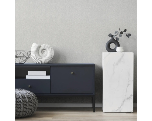 Aménagement intérieur avec commode, table d''appoint et décoration devant un papier peint à la structure discrète.