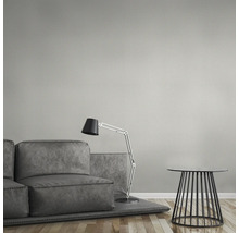 Ensemble de canapés gris avec lampadaire et table d''appoint devant un mur structuré