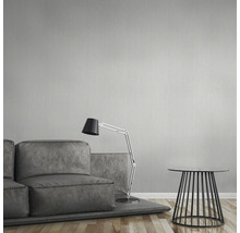 Salon avec papier peint gris, canapé, lampe et table d''appoint