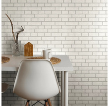 Espace de vie avec papier peint motif briques, table et chaise