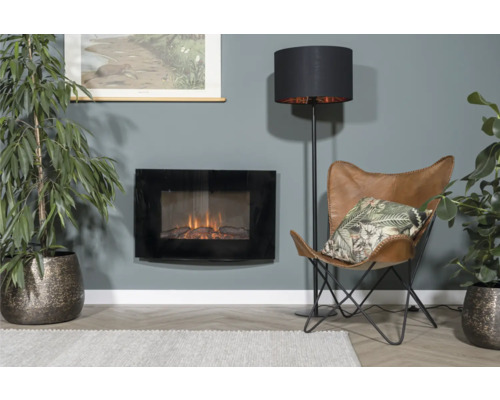 Salon avec cheminée électrique, lampadaire, fauteuil et plantes d''intérieur pour une ambiance chaleureuse