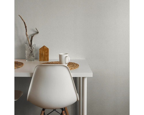 Scène avec table blanche, chaise, tasse, décoration en bois et vase en verre.