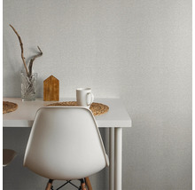 Scène avec un papier peint blanc, une table, une chaise, une tasse et des éléments décoratifs