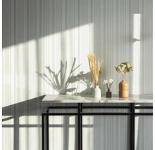 Éléments décoratifs sur une table devant un mur rayé