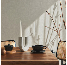 Table à manger dressée avec décoration et chaises dans une pièce lumineuse.