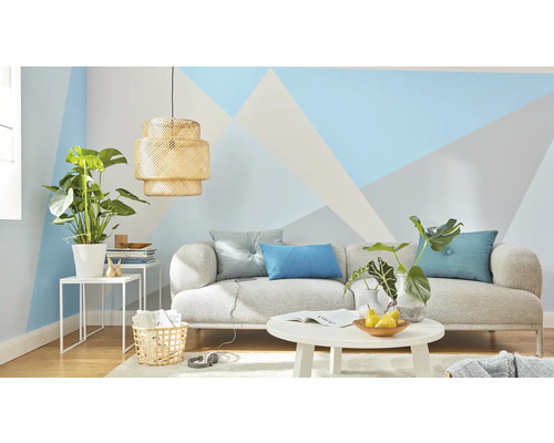 Helles Wohnzimmer mit Sofa, Tisch und Zimmerpflanzen